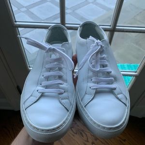 All white Woman common project sneakers